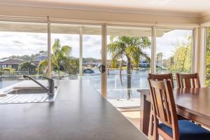 a kitchen with a table and a view of the water at Unbeatable Waterfront Location in Sussex Inlet