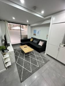 a living room with a black couch and a table at 2 BD Apt with Large Courtyard near The Star Casino in Sydney