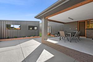 a patio of a house with a table and chairs at The Absolute Beach Escape For 21 in Saint Leonards