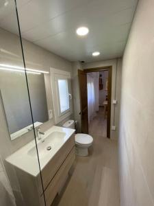 a bathroom with a sink and a toilet and a mirror at Apartament Ca l' Oriol in Guardiola de Berguedà