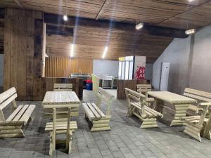 Cette chambre dispose de tables et de chaises en bois ainsi que d'une cuisine. dans l'établissement Backa idila, à Bački Gračac