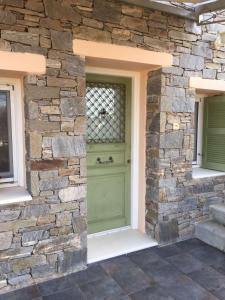 une porte d'entrée d'un bâtiment en pierre avec une porte verte dans l'établissement ΚΑΛΛΙΣΤΗ HOUSE, à Posidhonía