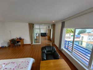 May Beach Resort في جزيرة كوه رونغ: غرفة معيشة مع كرسي ونافذة كبيرة