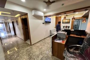 a man standing at a desk in an office at Hotel Moon Light Isanpur Ahmedabad in Bātwa