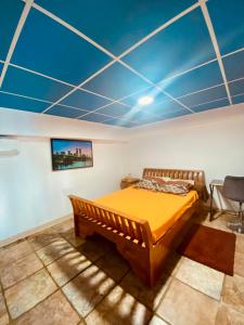 a bedroom with a bed and a blue ceiling at Payanké in La Possession