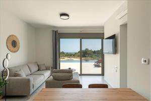 a living room with a couch and a table at Brand New: Kefalonia Stone Villas - Villa Trapezaki Retreat in Trapezaki