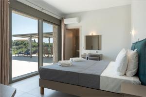 a bedroom with a large bed and a balcony at Brand New: Kefalonia Stone Villas - Villa Trapezaki Retreat in Trapezaki +63 photos