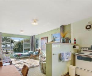 a kitchen with a stove and a living room at Motuoapa Lakeside Retreat in Turangi