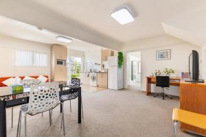 cocina y sala de estar con mesa y sillas en Your home at Cockle Bay en Auckland