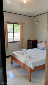 a bedroom with two beds and a window at Zara's Casa Rental in Siquijor
