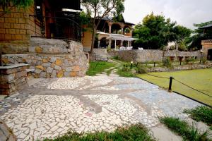 a stone walkway in front of a building at Arbor Road Estate in Pāmalparti +5 photos