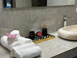a bathroom with towels and a sink and a mirror at Vila Anda in Eforie Sud