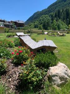 een stenen bank in een tuin met bloemen bij Residence Altea in Ortisei