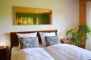 a bedroom with a bed with two pillows and a mirror at Augenweide in Prien am Chiemsee