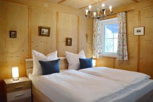 a bedroom with a large white bed with a window at BayernBlick in Rimsting