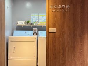 a door leading to a laundry room with a refrigerator at Chaiin Hotel - Dongmen in Taipei