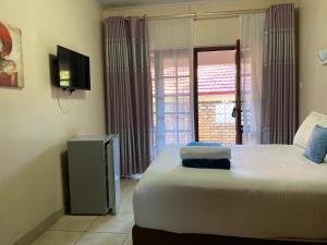 a bedroom with a bed with two towels on it at Matilinda Lodge in Bulawayo +34 photos