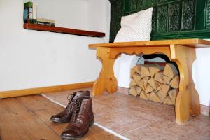 un par de botas junto a una mesa con chimenea en BergZeit en Aschau im Chiemgau