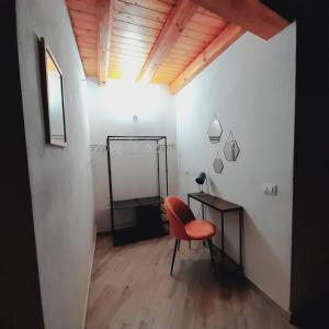 Habitación con silla roja y escritorio. en Enzo'S Suite en Palermo