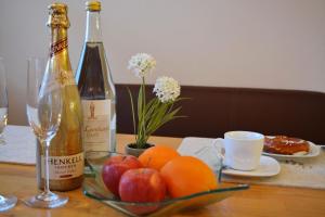 einen Tisch mit einer Glas Obstschale und einer Flasche Wein in der Unterkunft Chiemseenest in Prien am Chiemsee