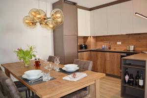 una cocina con una mesa de madera con platos y copas de vino en Burgblick, en Marquartstein