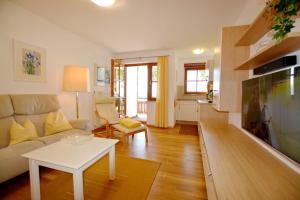 ein Wohnzimmer mit einem Sofa und einem Tisch in der Unterkunft Ferienresidenz Chiemseestrand - Apartment 14 in Chieming