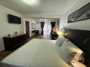 a bedroom with a large white bed with a desk at Vila Anda in Eforie Sud +14 photos