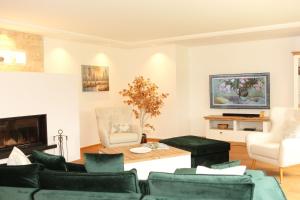 uma sala de estar com mobiliário verde e uma lareira em ChiemseeZeit em Gstadt am Chiemsee