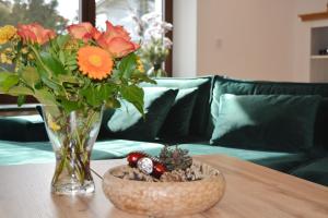 um vaso de flores sobre uma mesa com uma tigela de flores em ChiemseeZeit em Gstadt am Chiemsee