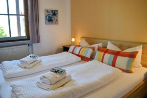 een slaapkamer met 2 bedden en handdoeken bij Ferienresidenz Chiemseestrand - Apartment 28 in Chieming