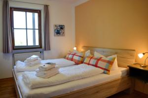 een slaapkamer met een bed met handdoeken erop bij Ferienresidenz Chiemseestrand - Apartment 28 in Chieming