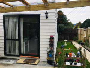 a tiny house with a sliding glass door at West Auckland Delight Stay in Auckland