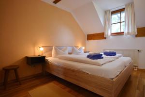 a bedroom with a bed with white sheets and a window at Ferienresidenz Chiemseestrand - Apartment 31 in Chieming