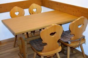 une table en bois entourée de 4 chaises en bois dans l'établissement Ferienresidenz Chiemseestrand - Seebruck, à Chieming