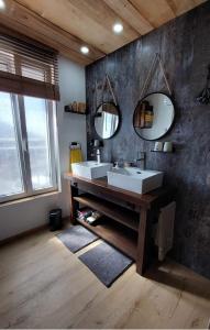 a bathroom with two sinks and two mirrors at Gite & Spa Au pommier fleuri et son "Appart" indépendant in Drusenheim