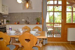 eine Küche mit einem Holztisch mit Stühlen und einem Tisch in der Unterkunft Ferienresidenz Chiemseestrand - Sunset 17 in Chieming