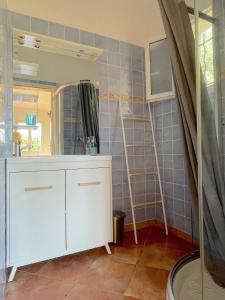 uma casa de banho com um armário branco e um espelho em Maison au calme avec jardin et parking, proche de tout ! em La Ciotat