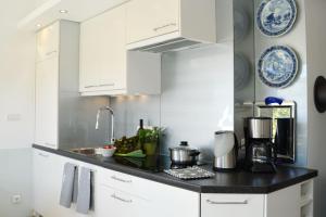 une cuisine avec des placards blancs et un comptoir noir dans l'établissement Haus Sandra, à Prien am Chiemsee