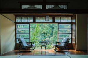 Duas cadeiras num quarto com uma grande janela em Ochiairo em Izu