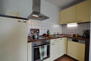 cocina con armarios blancos y fogones en Meisterhof - Hartsee, en Eggstätt