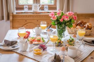 einen Tisch mit Speisen und Gläsern aus Orangensaft und Blumen in der Unterkunft Möderlhof - Fraueninsel in Eggstätt