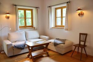 sala de estar con sofá, mesa y 2 ventanas en nock her berge, en Marquartstein