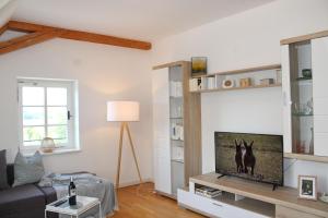 een woonkamer met een bank en een flatscreen-tv bij Schloss Winkl in Grabenstätt