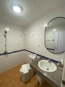 a bathroom with a sink and a toilet and a mirror at Kata beach townhouse in Kata Beach +15 photos
