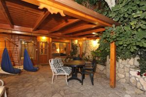 a patio with a table and chairs and a building at Ohn-Bar Guesthouse in Amirim