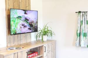 einen Flachbild-TV auf einem hölzernen Entertainment-Center in der Unterkunft Wieserhof-Kampenwand in Bernau am Chiemsee