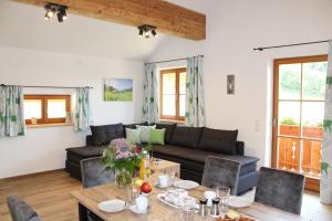 ein Wohnzimmer mit einem Sofa und einem Tisch in der Unterkunft Wieserhof-Kampenwand in Bernau am Chiemsee