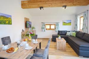 ein Wohnzimmer mit einem Tisch und einem Sofa in der Unterkunft Wieserhof-Kampenwand in Bernau am Chiemsee