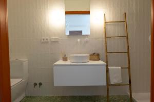 uma casa de banho com um lavatório, um WC e uma escada em RaíZes 22 - Apartamento 6 em Puebla de Don Fadrique