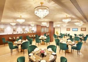 a dining room with tables and chairs and chandeliers at Accord Chrome in Chennai